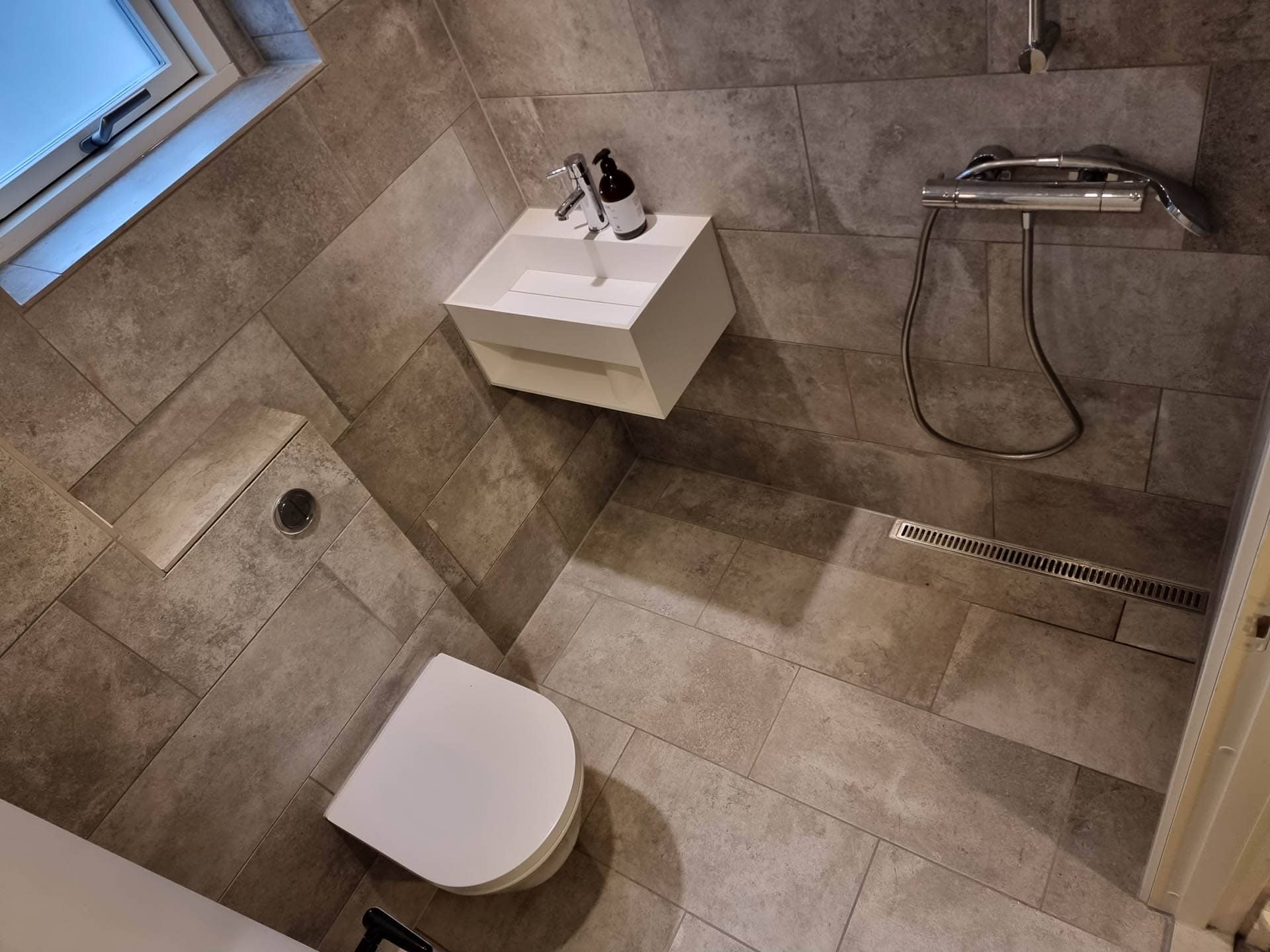 Bruseniche, håndvask og toilet på badeværelse.